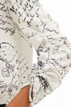 Blouse with adjustable sleeves and text prints.